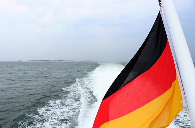 Dieses Bild zeigt die Bundesflagge an einem Boot auf dem Meer. Photo by Clemens van Lay on Unsplash